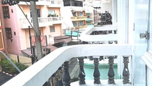A balcony with a balustrade overlooking a residential area with multi-story buildings. - Marine Guest House Encore (Pattaya)