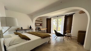 Une chambre d’hôtel moderne équipée d’un lit, d’un bureau et d’un coin salon.