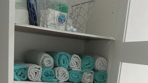 A storage area with shelves holding rolled towels in various colors. - Bangor - 2 Bed Apartment- Sleeps 4 -privateparking (Bangor)