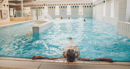 Wellness bungalow with whirlpool, sauna, sunshower, 3 bedrooms, and a covered terrace with lounge set.