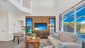 A spacious living room with a large window, a wooden accent wall, and a comfortable seating area.