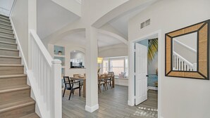 A spacious interior with a staircase, dining area, kitchen, and open-plan living space.