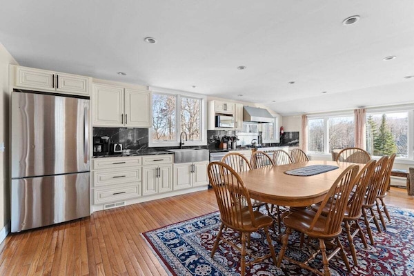 Chef's kitchen and stylish dining area with views to the Killington landscape in this slopeside 4-bedroom home.