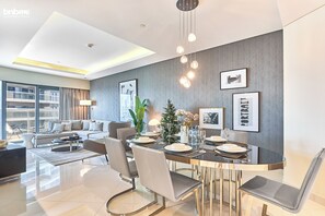 Ein modernes Wohnzimmer mit Essbereich, ausgestattet mit einer Sofagarnitur, einem Couchtisch und einem Esstisch mit Stühlen.