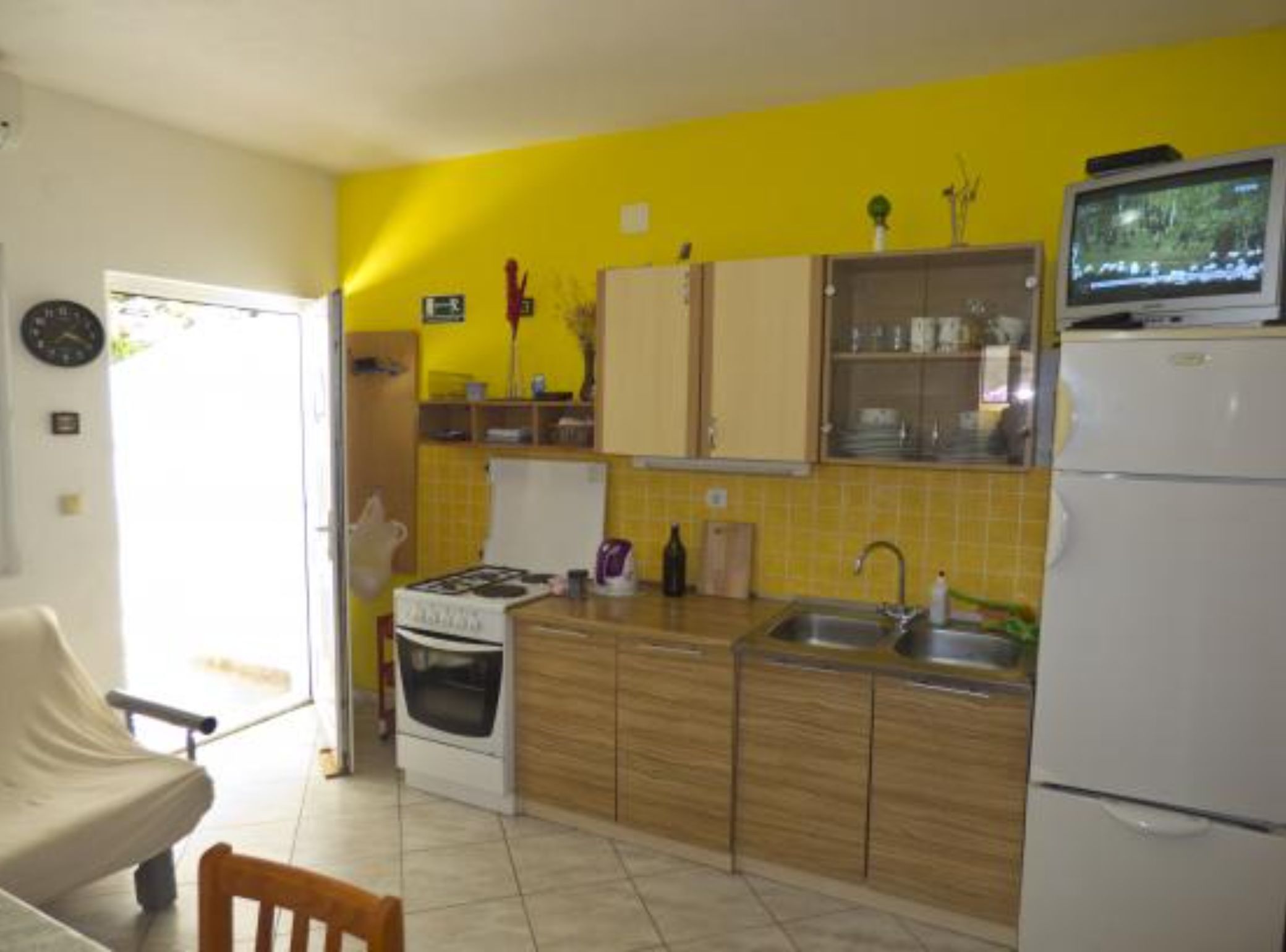 A compact kitchen with a stove, sink, and refrigerator.