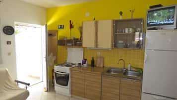 A compact kitchen with a stove, sink, and refrigerator.