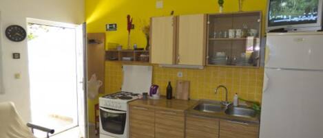 A compact kitchen with a stove, sink, and refrigerator.