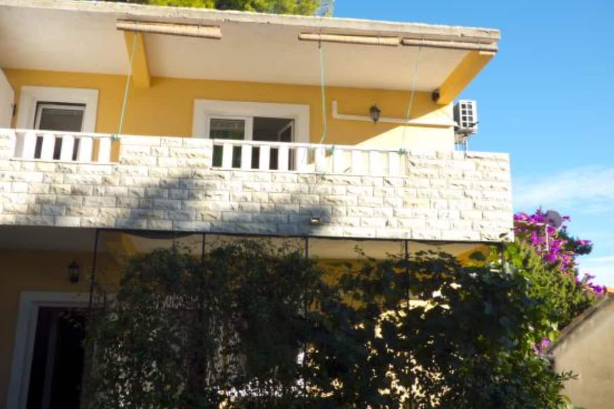 Un immeuble de deux étages doté d’un balcon, d’une fenêtre et d’une antenne parabolique.