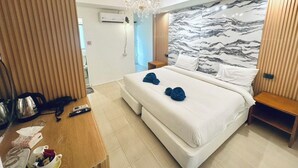 Camera d'hotel moderna con un letto grande, un lampadario, una parete decorata con motivi marmorei e un pannello in legno.