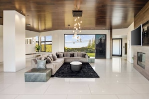 A modern living room with a sectional sofa, a round coffee table, and a black rug.