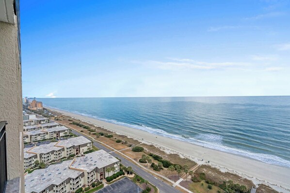 A beachfront hotel with multiple buildings, a sandy beach, and the ocean.