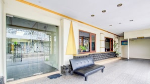 A reception area with a reception desk, a black leather sofa, and a glass door leading to the outside. - Hotel O Jalan Malioboro Near Stasiun Tugu Yogyakarta Formerly Hotel Baru (Yogyakarta)