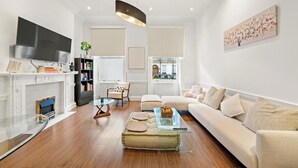 Una sala moderna con chimenea, sofá y televisión.