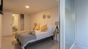 A modern bedroom with a bed, bedside lamps, and a window. - Urban apartment Santa Rosa Ideal for Couples (Santiago)