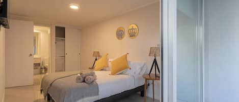 Een moderne slaapkamer met een bed, bedlampen en een raam.