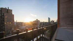 A balcony with a cityscape view during sunset. - Urban apartment Santa Rosa Ideal for Couples (Santiago)