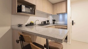 A compact kitchen with a granite countertop, a microwave, a toaster, and a sink. - Urban apartment Santa Rosa Ideal for Couples (Santiago)
