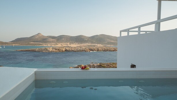 Una piscina con vistas al mar y a las montañas.