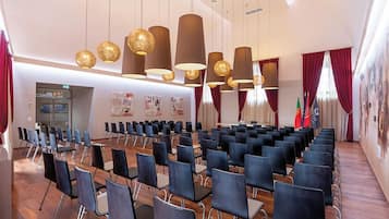 A conference room with rows of chairs, a whiteboard, and a podium.