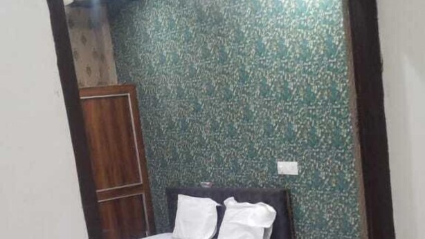 Een slaapkamer met een bed, nachtkastje en kledingkast.