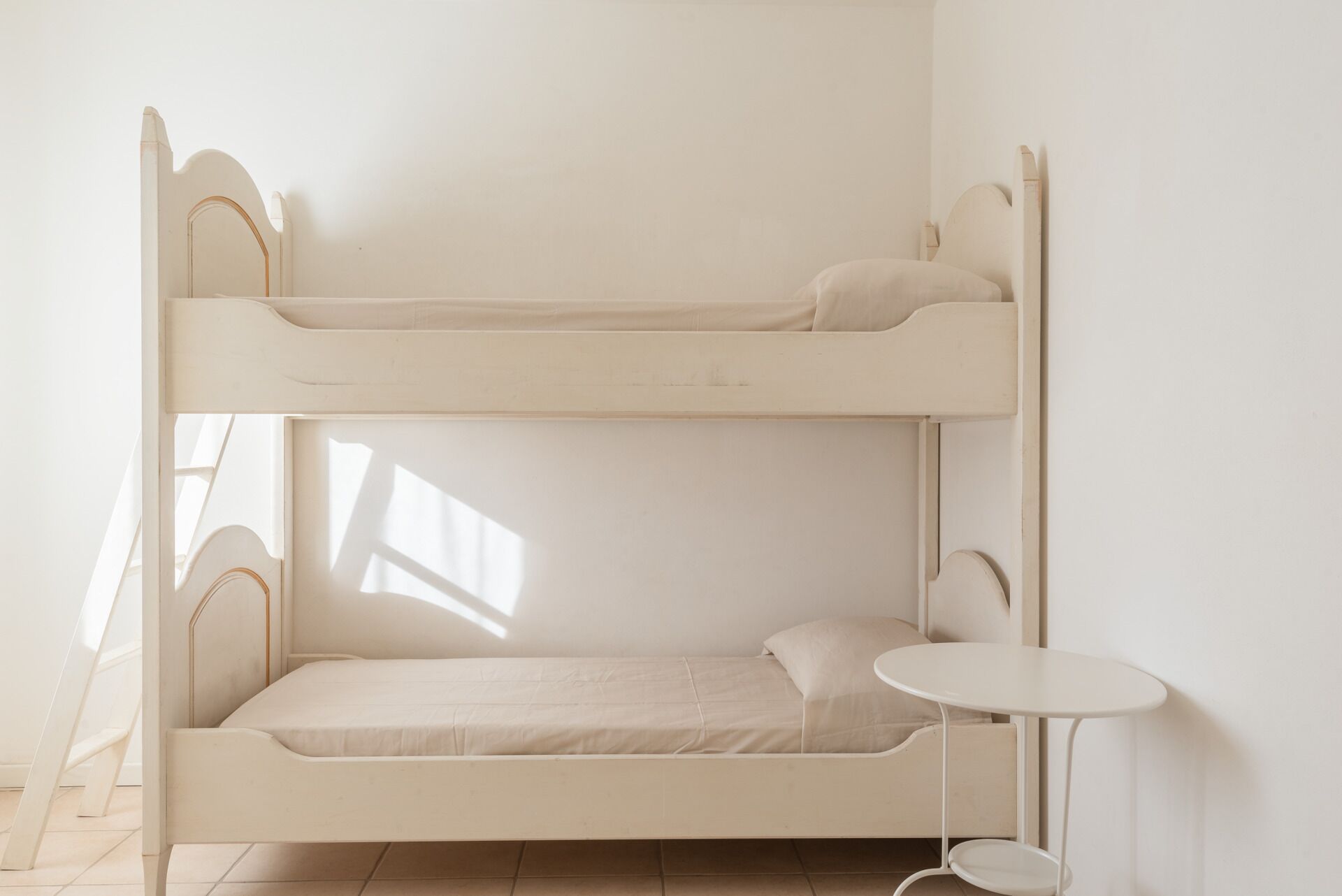A bunk bed with a small table beside it.