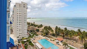 A high-rise hotel with a pool and beach view.