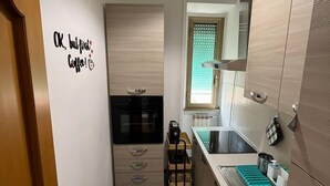 A compact kitchen with a built-in oven, a coffee machine, and a sink. - BalduinaView, in the residential neighborhood of Balduina just minutes from the Vatican (Roma)
