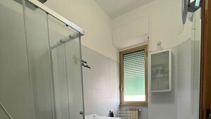 A modern bathroom with a glass shower enclosure, a sink, and a toilet. - BalduinaView, in the residential neighborhood of Balduina just minutes from the Vatican (Roma)