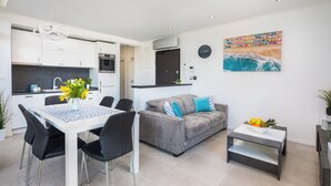 A modern apartment with a dining area, kitchen, living room, and a large window. - Villa Muller Apartments (Split)