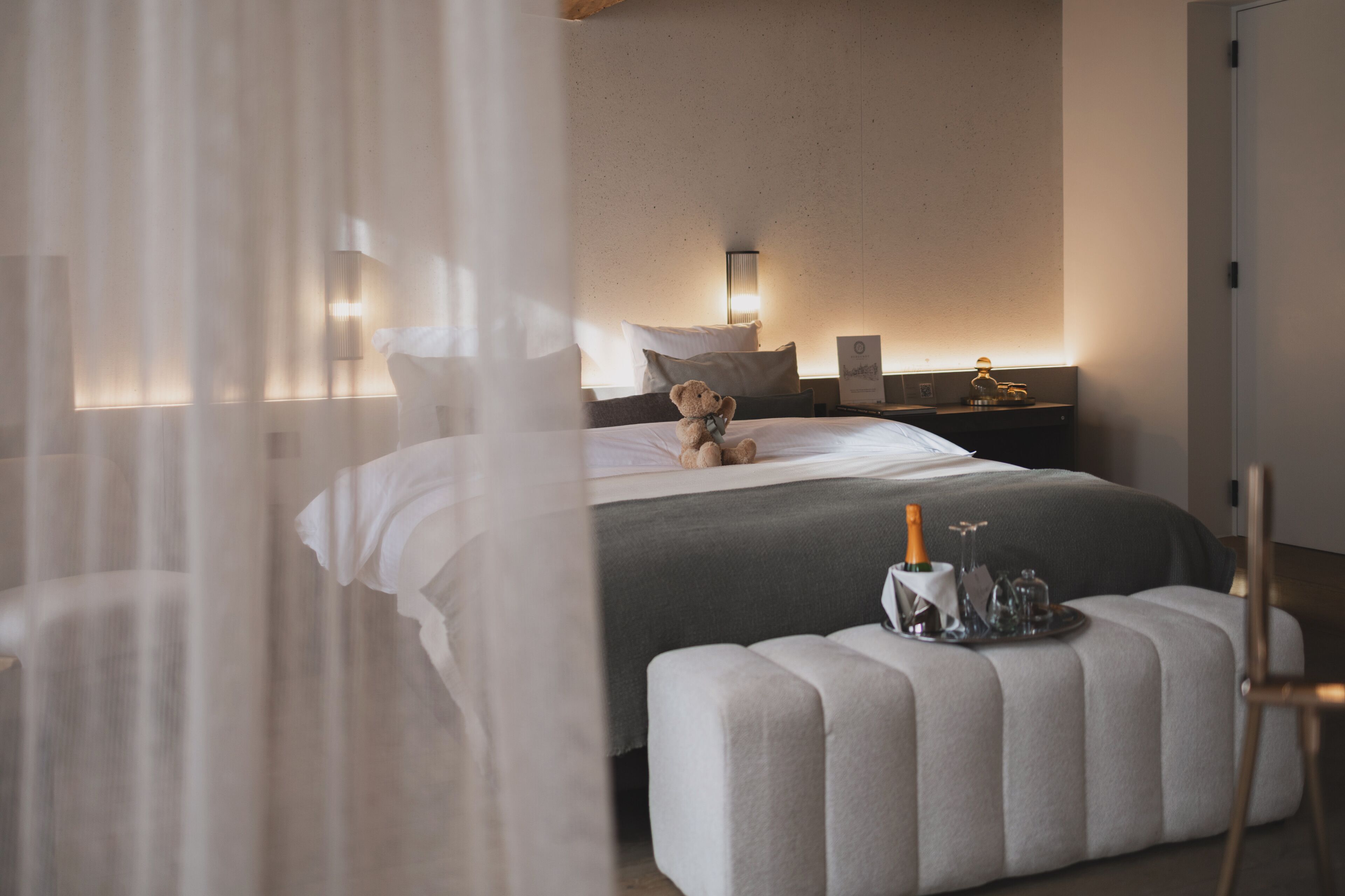 A bedroom with a bed, bedside table, and a bedside lamp.