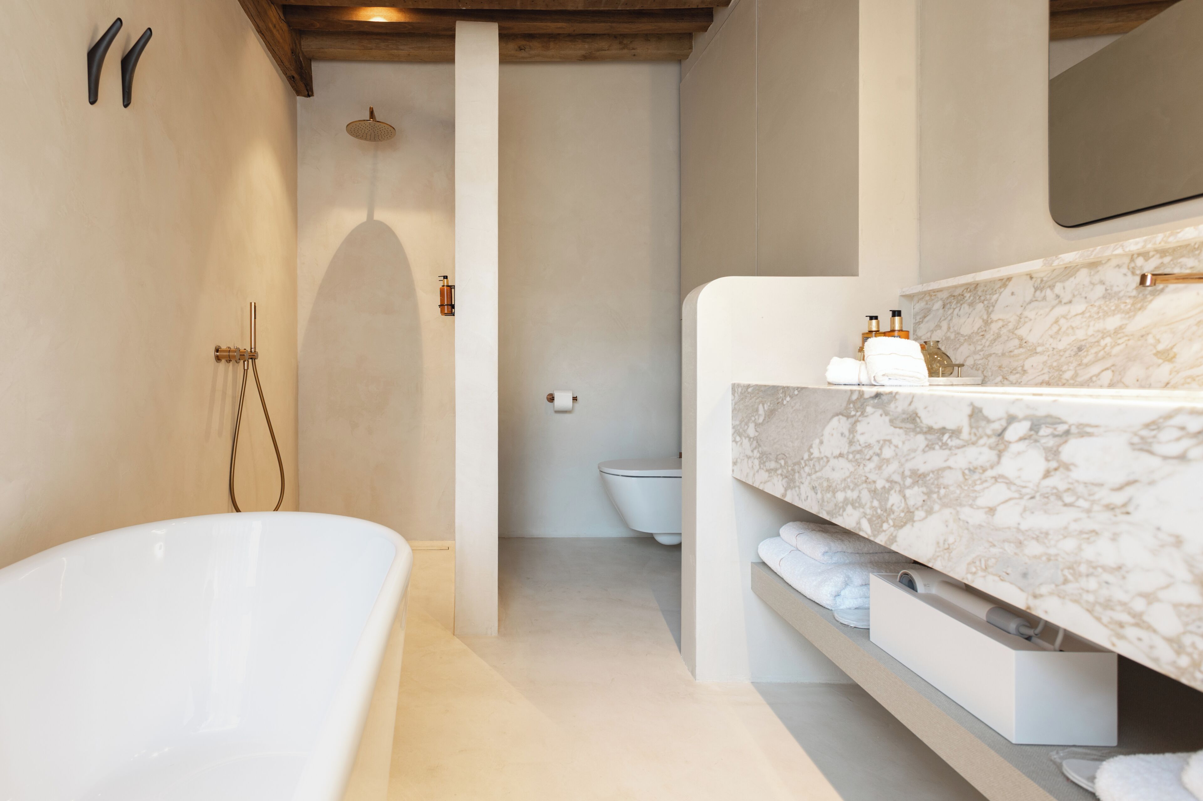 Ein modernes Badezimmer mit freistehender Badewanne, einem мраморном Waschbecken und einer separaten Toilette.