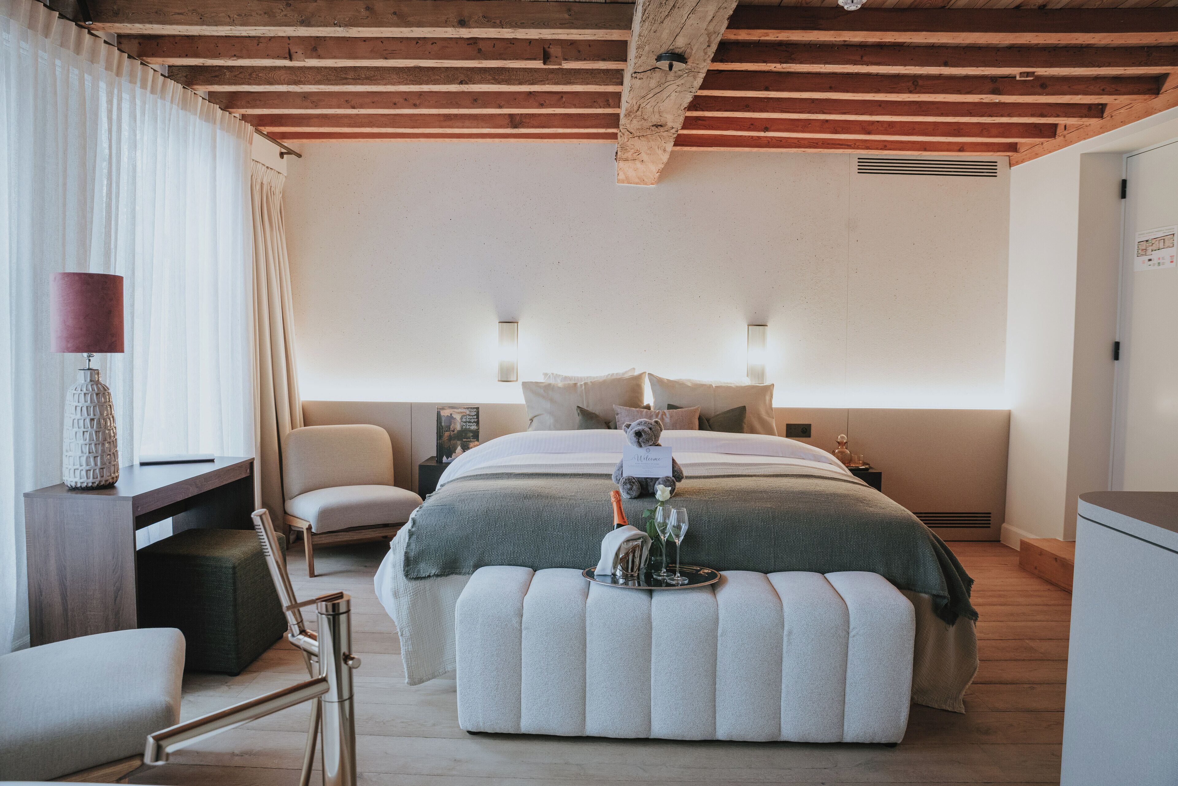 Ein Schlafzimmer mit Bett, Nachttisch, Stuhl und kleinem Schreibtisch mit Lampe.