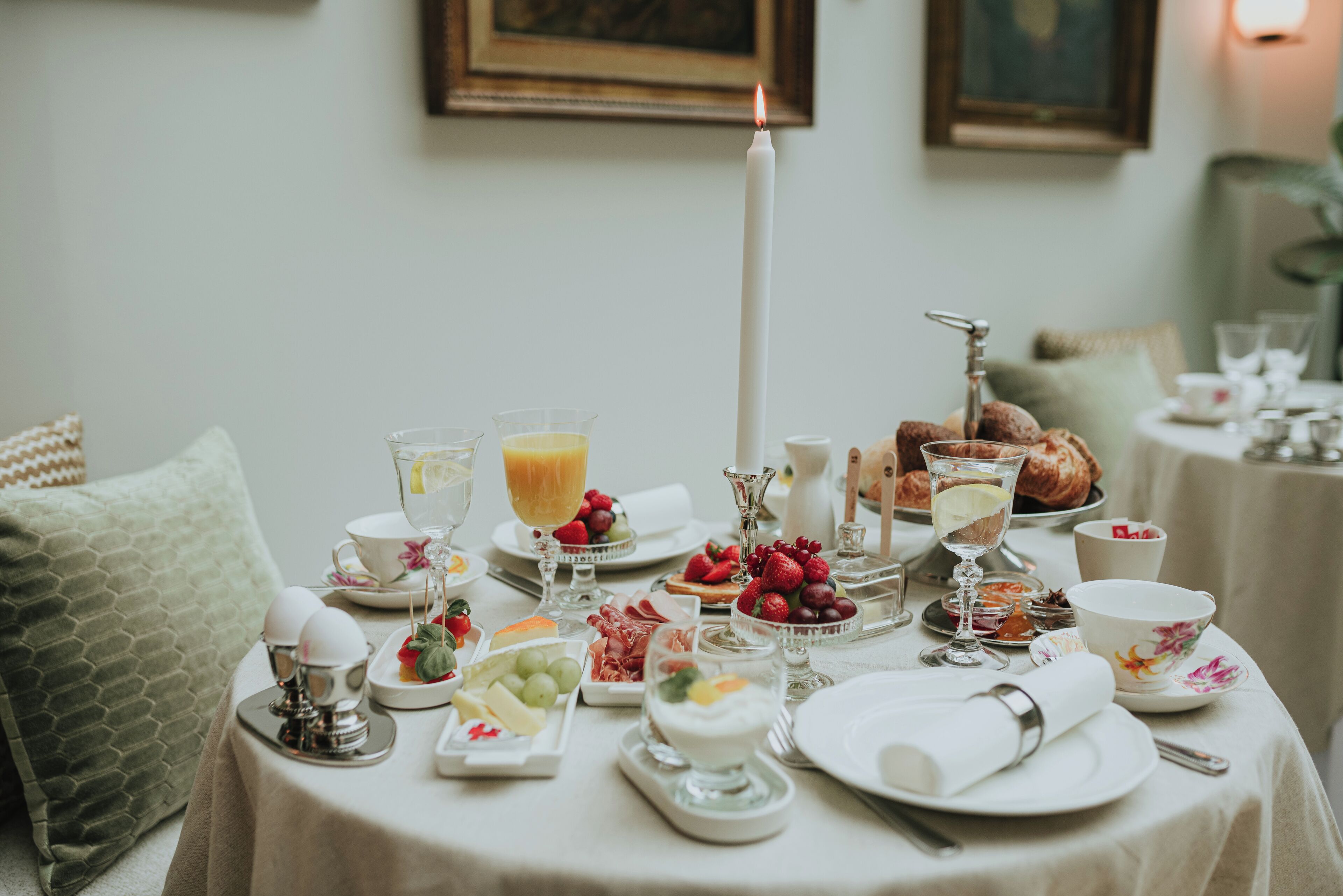 Una mesa de desayuno dispuesta con diversos alimentos, como frutas, pasteles y bebidas.