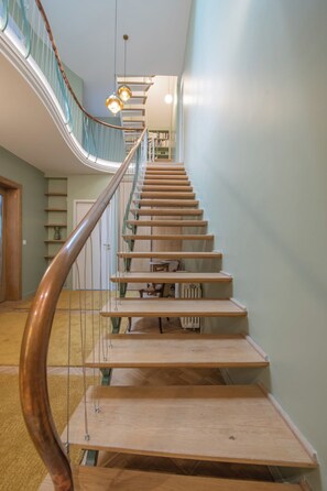 A wooden staircase with a glass railing and a spiral design.