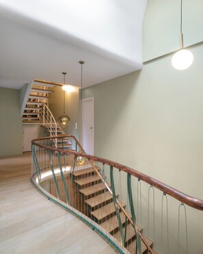 A staircase with wooden steps and a green metal railing, leading to a landing with a white door. - Le Blanc Meix - 8 guests - Sauna, near the lake, Gérardmer (Gérardmer)