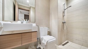 Une salle de bain moderne avec un lavabo blanc, un miroir et des toilettes.
