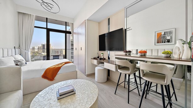 Une chambre d’hôtel moderne dotée d’un grand lit, d’un coin repas avec télévision et d’une vue sur la ville.