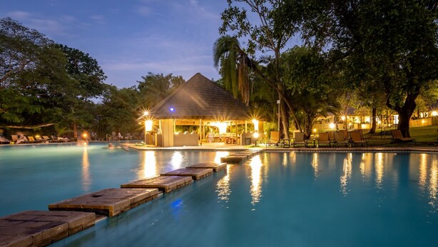 A pool area with a gazebo and lounge chairs. - First Group Sanbonani Resort (Mbombela)