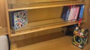 A wooden shelf with glass jars and books. - Narrowboat in Birmingham City (Birmingham)