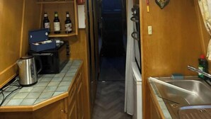 A compact kitchen with a sink, a coffee maker, and a small refrigerator. - Narrowboat in Birmingham City (Birmingham)