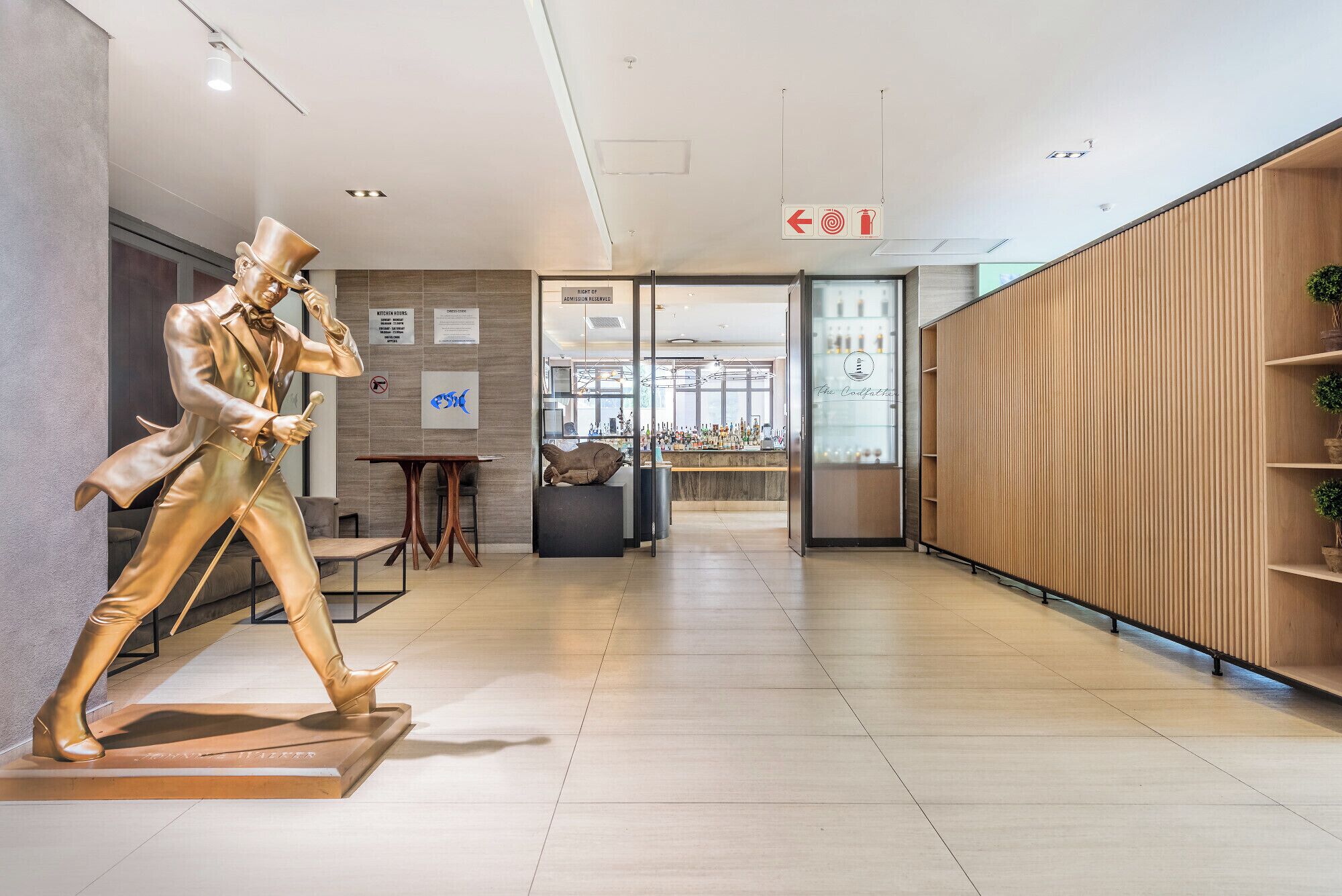 A modern interior with a statue, a bar area, and a wooden partition.
