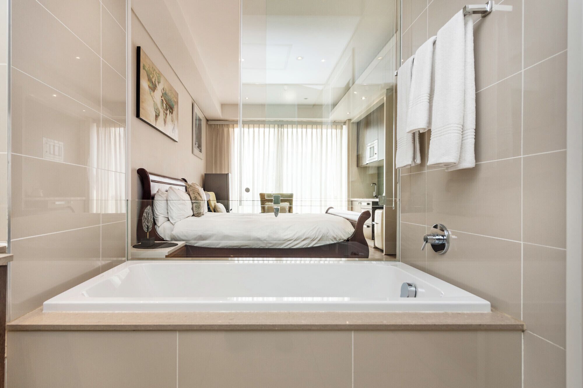 A modern bathroom with a large bathtub, a shower area, and a vanity with a mirror.