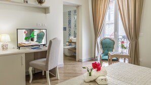 Une chambre d’hôtel équipée d’un bureau, d’une chaise, d’un lit et offrant une vue sur le balcon.