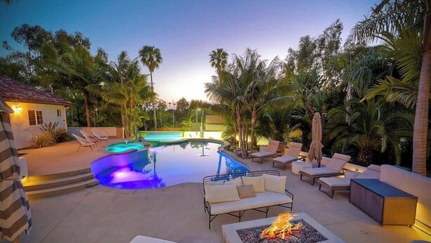 A pool area with lounge chairs, a fire pit, and a small building. - Luxury Sanctuary Retreat-Heated pool-Hot tub-Volleyball (Encinitas)