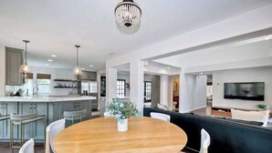 A modern kitchen with a central island, white cabinetry, and pendant lighting. - Luxury Sanctuary Retreat-Heated pool-Hot tub-Volleyball (Encinitas)