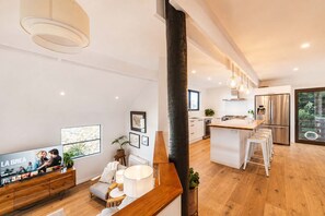 Una cocina moderna con una isla central, electrodomésticos de acero inoxidable y un ventanal grande.