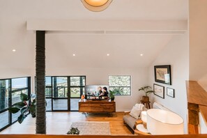 A spacious living area with a large window, a wooden coffee table, and a sofa.