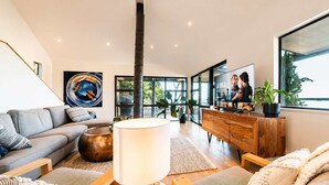 A modern living room with a sofa, coffee table, and a TV on a wooden cabinet.