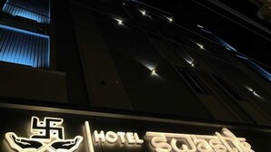 A hotel sign with illuminated neon lights, including a logo and name. - Hotel Swastik (Amritsar)
