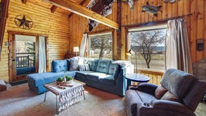 A log cabin interior with a sectional sofa, a coffee table, and a fireplace. - Mtn-view Cabin w/ Horse Pasture in Koosharem (Koosharem)